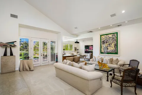 a dining room with furniture and a floor to ceiling window