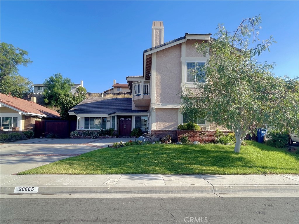 a front view of a house with a garden and yard