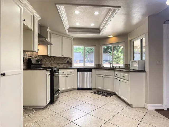 a kitchen with granite countertop white cabinets and white appliances