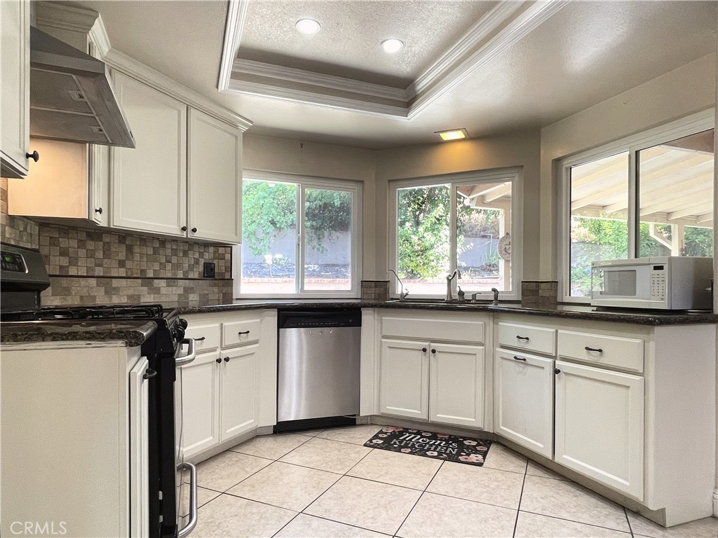 20665 Fuero Drive Walnut, CA 91789 - Photo 14 of 47 a kitchen with granite countertop white cabinets white appliances a sink and a window