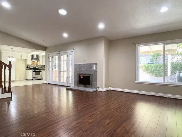 an empty room with wooden floor and a fireplace