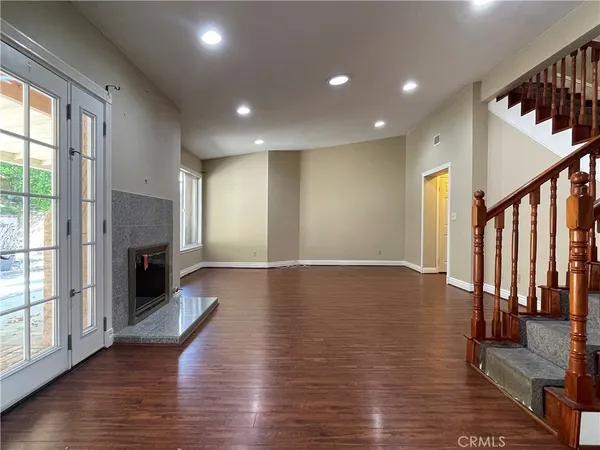 a view of a livingroom with wooden floor and a fireplace