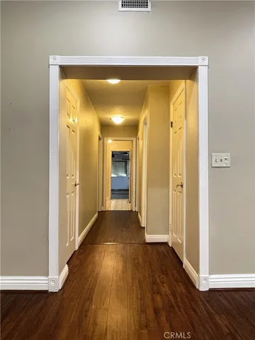a view of a hallway with wooden floor