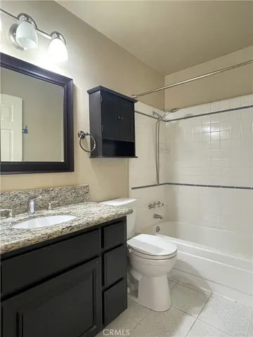 a bathroom with a granite countertop sink a toilet and a mirror