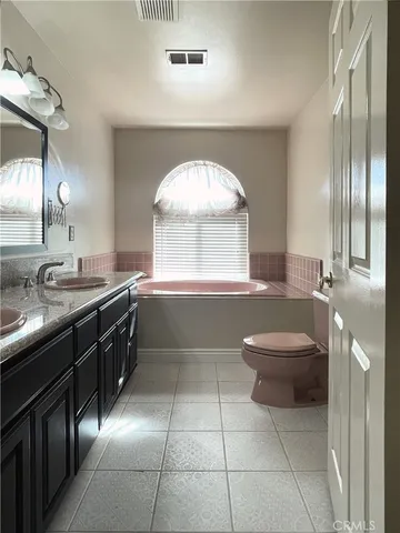 a bathroom with a sink a toilet a mirror and window