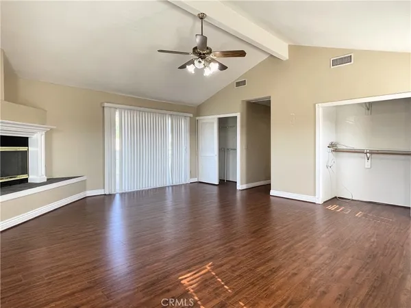 a view of a livingroom with wooden floor and a ceiling fan