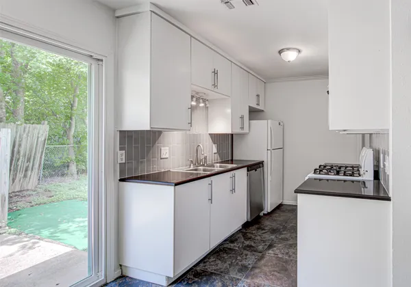 a kitchen with stainless steel appliances granite countertop a stove a refrigerator a sink and a cabinets