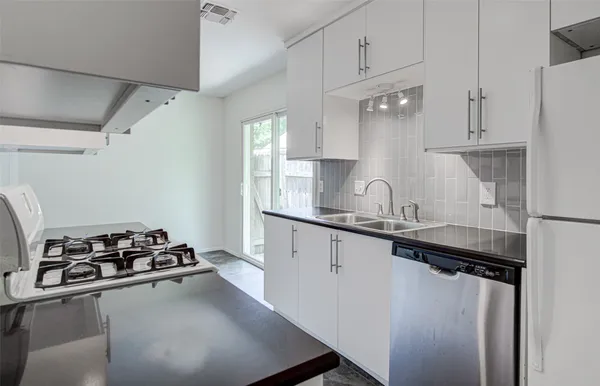 a kitchen with sink stove and cabinets