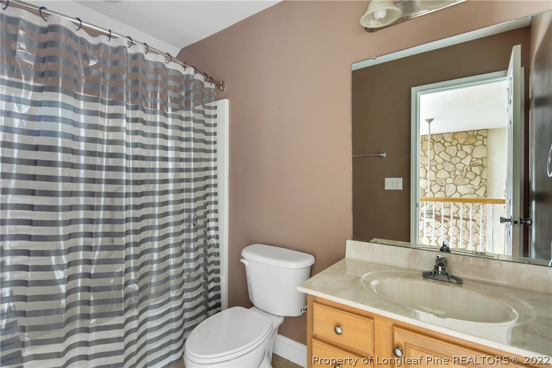 187 Lamplighter Way Spring Lake, NC 28390 - Photo 35 of 48 a bathroom with a granite countertop toilet a sink a mirror and shower