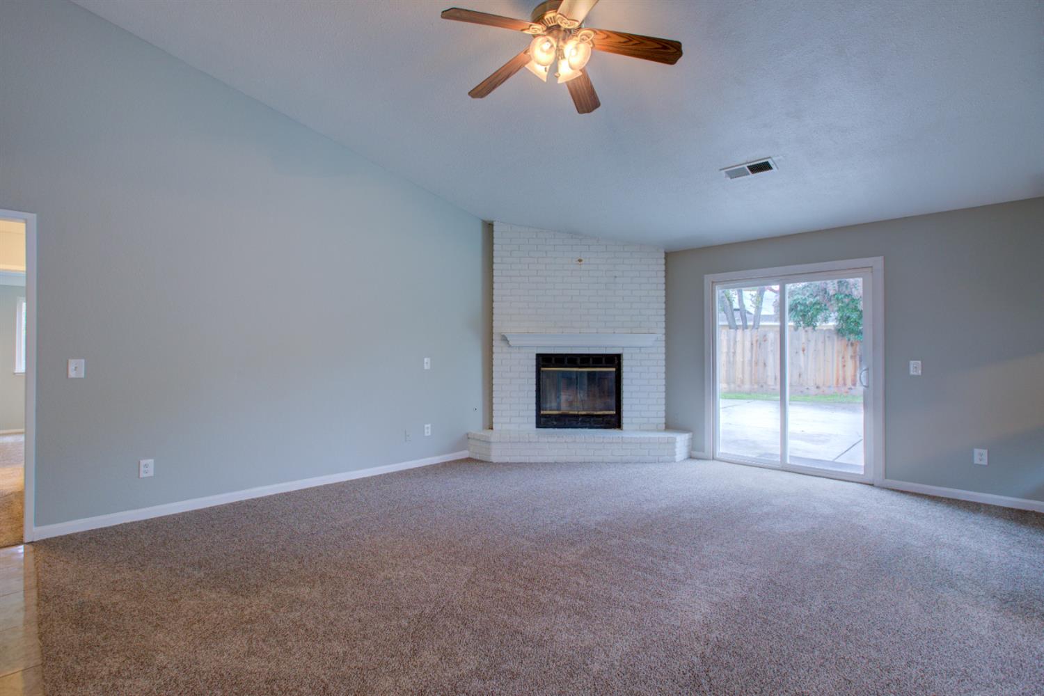3772 Duke Court Merced, CA 95348 - Photo 9 of 40 a view of an empty room with a fireplace and a window