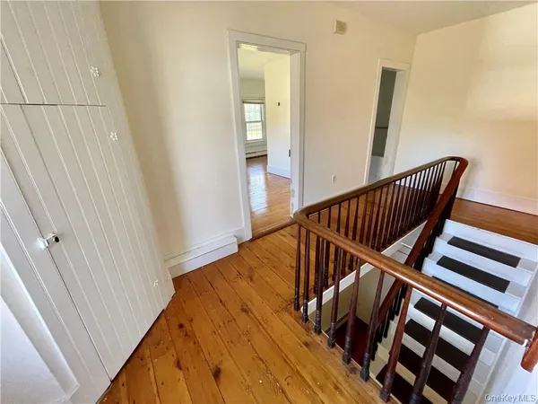 a view of staircase with railing and white walls
