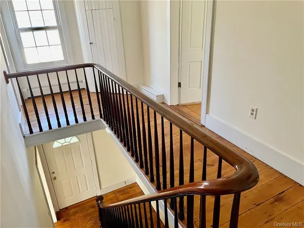 a view of staircase with railing and a window