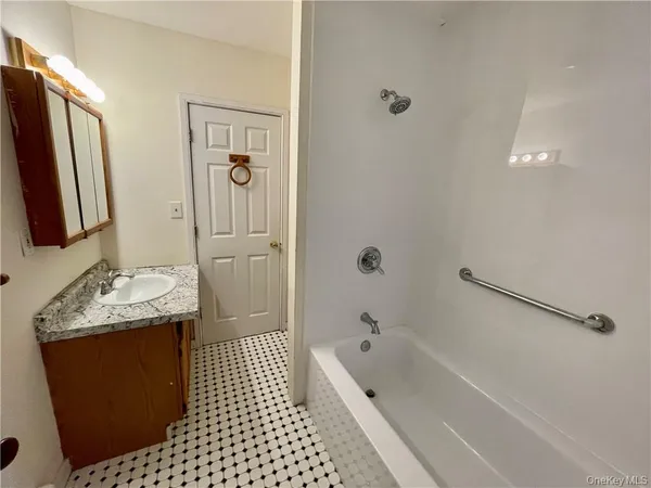 a bathroom with a granite countertop sink a mirror and shower