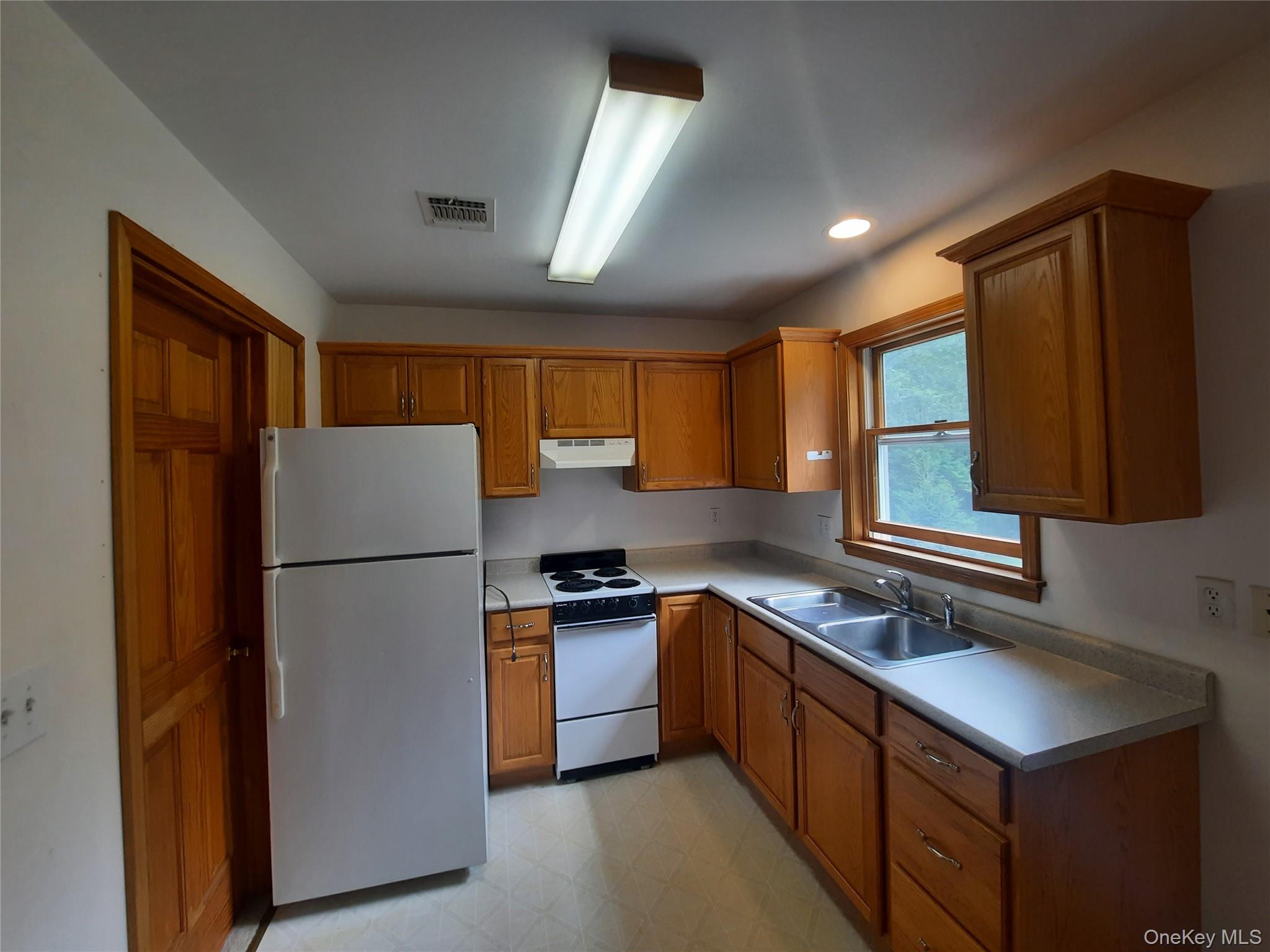 339 Kirbytown Road Middletown, NY 10940 - Photo 40 of 44 a kitchen with a refrigerator a stove a sink dishwasher and wooden cabinets