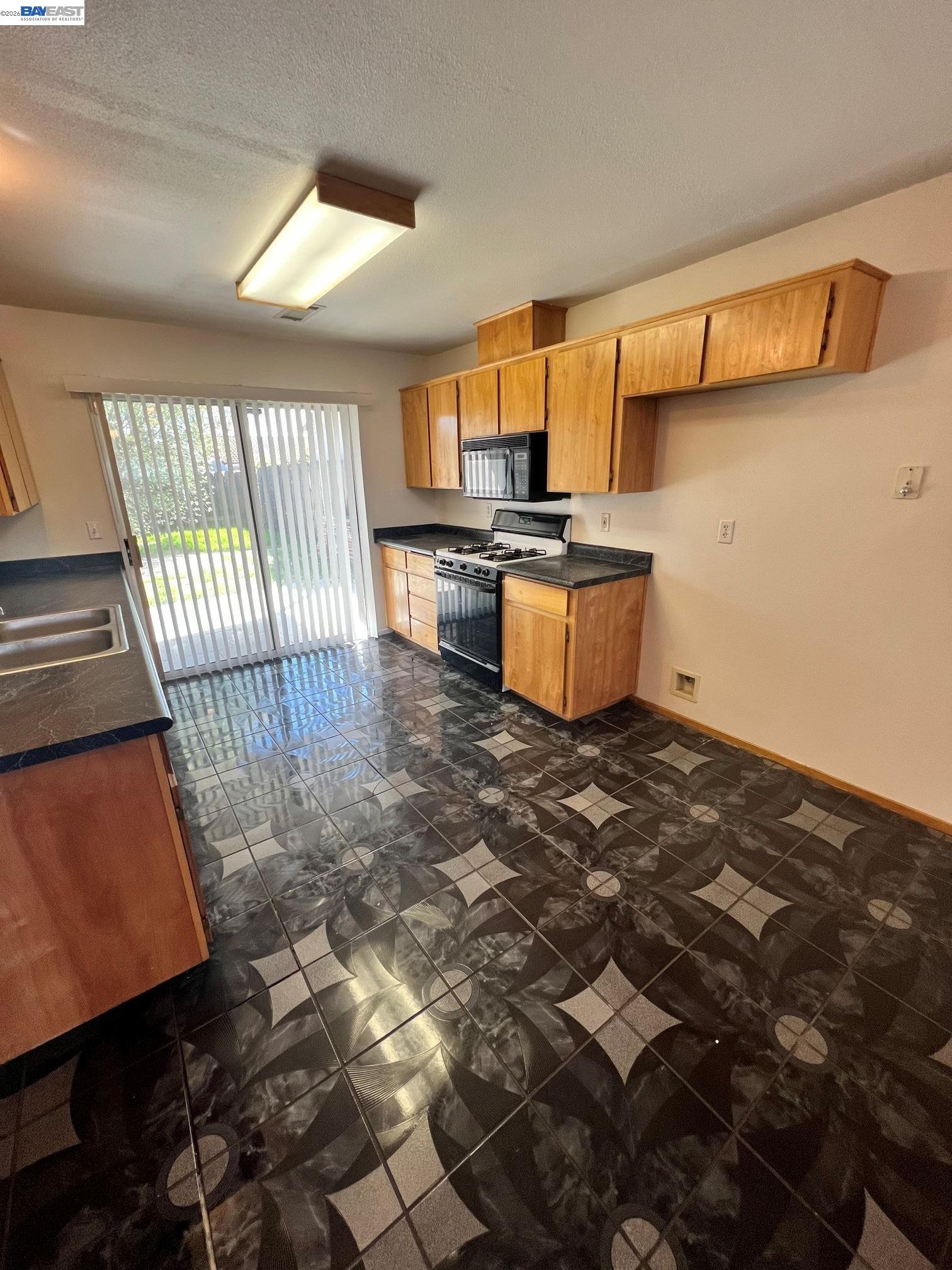 192 Torvend Way Patterson, CA 95363 - Photo 7 of 29 a kitchen with stainless steel appliances wooden cabinets and a stove top oven