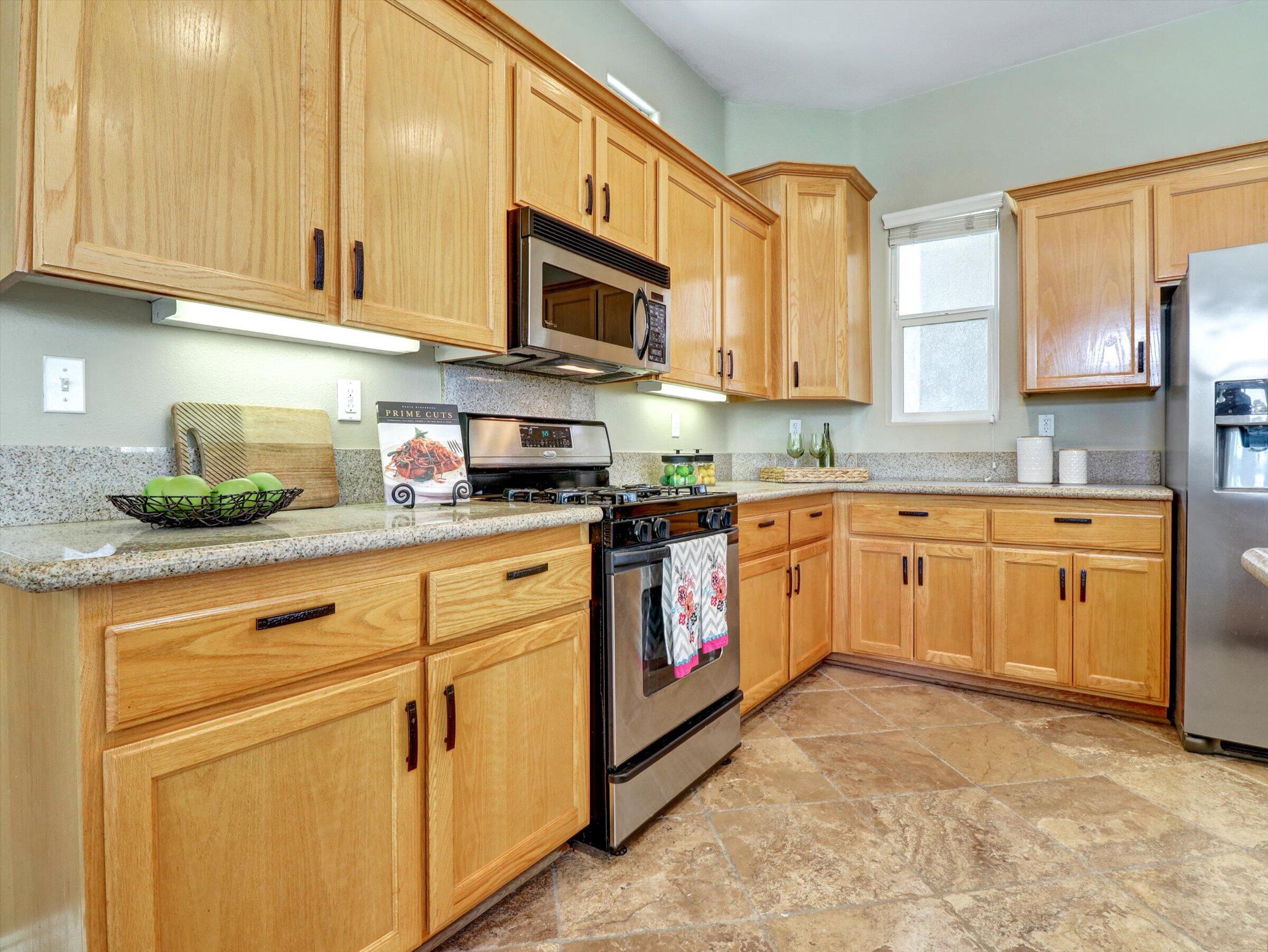 82809 Odlum Drive Indio, CA 92201 - Photo 19 of 57 a kitchen with stainless steel appliances granite countertop white cabinets sink and window