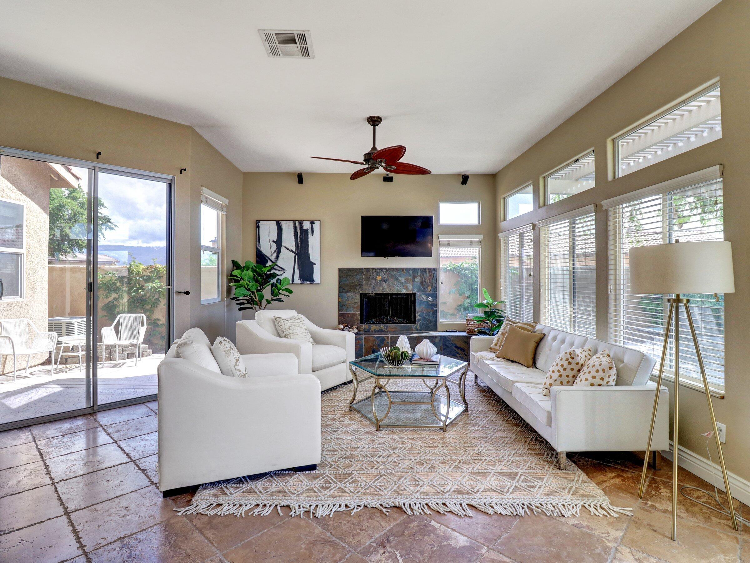 82809 Odlum Drive Indio, CA 92201 - Photo 6 of 57 a living room with furniture a fireplace and a large window