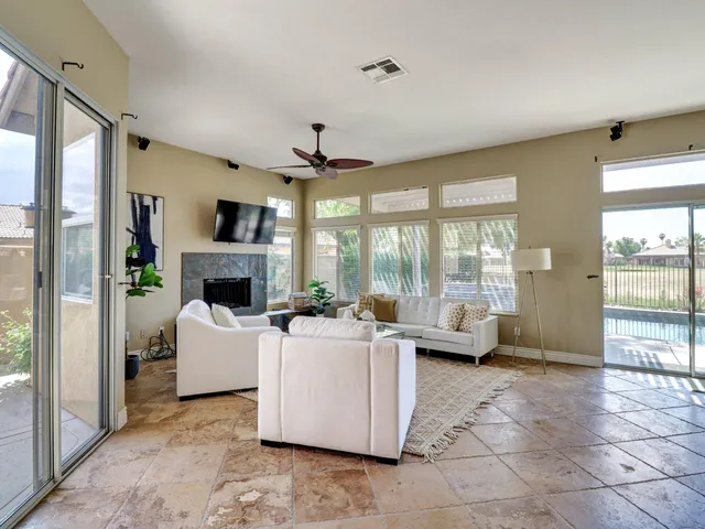 a living room with furniture a large window and a fireplace