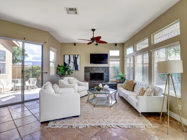 a kitchen with stainless steel appliances kitchen island granite countertop dining table chairs and a refrigerator