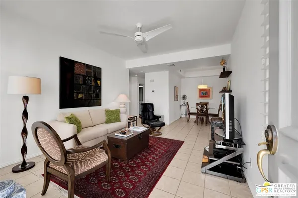 a living room with patio furniture and a flat screen tv