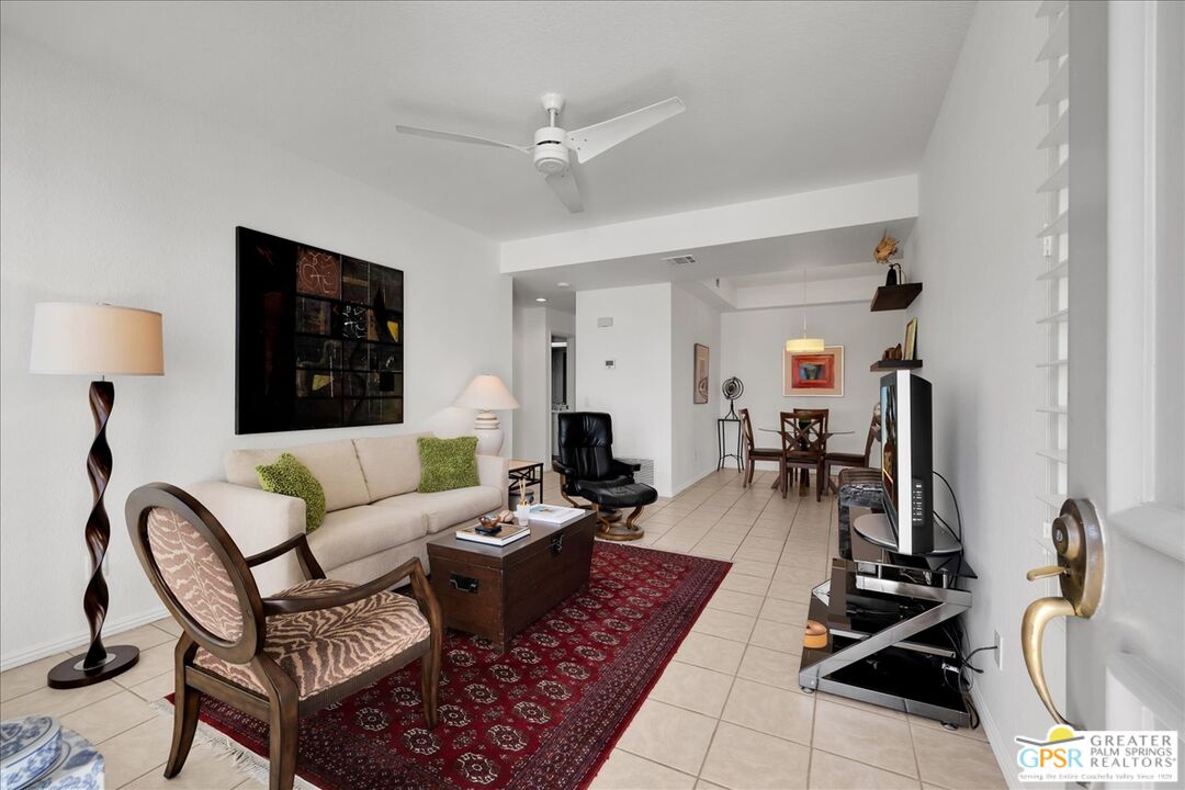 a living room with patio furniture and a flat screen tv