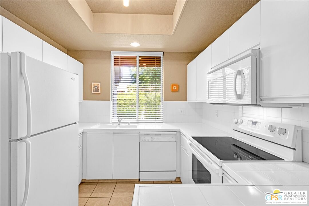 401 El Cielo Road, Unit 227 Palm Springs, CA 92262 - Photo 11 of 45 a kitchen that has a sink cabinets counter space and appliances