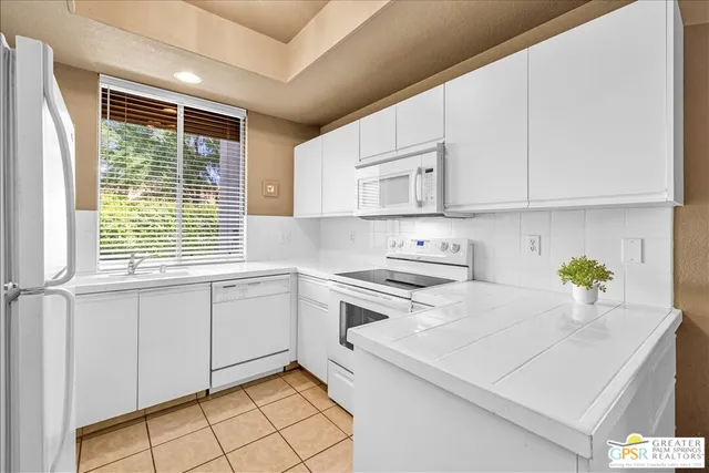 a kitchen with a white cabinets and window