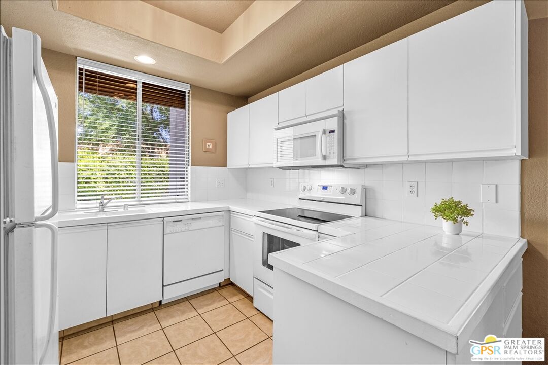 401 El Cielo Road, Unit 227 Palm Springs, CA 92262 - Photo 12 of 45 a kitchen with a white cabinets and window
