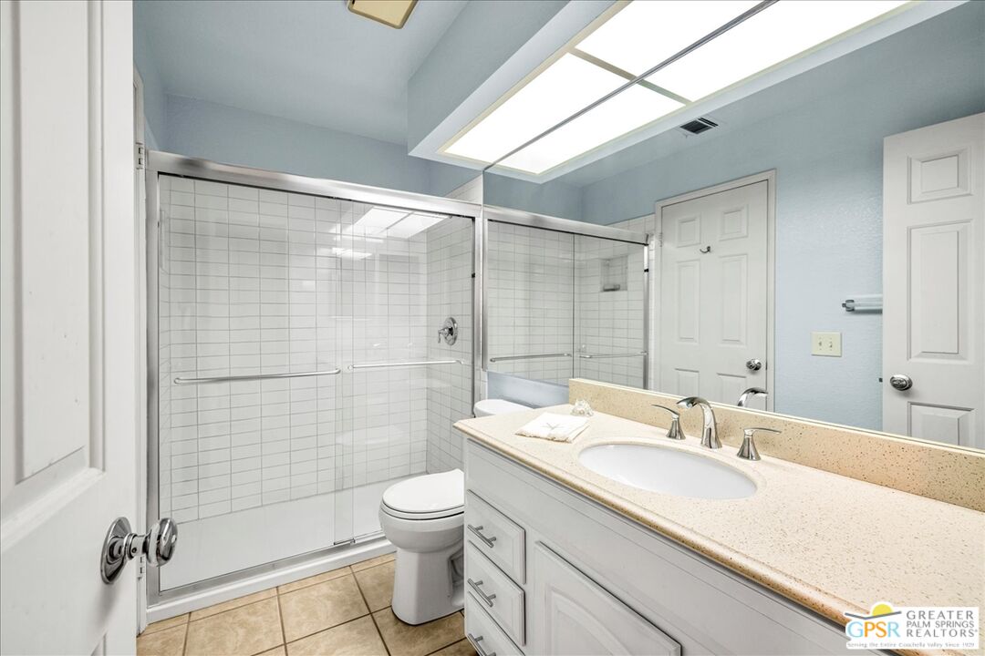 401 El Cielo Road, Unit 227 Palm Springs, CA 92262 - Photo 15 of 43 a bathroom with a granite countertop sink toilet and shower