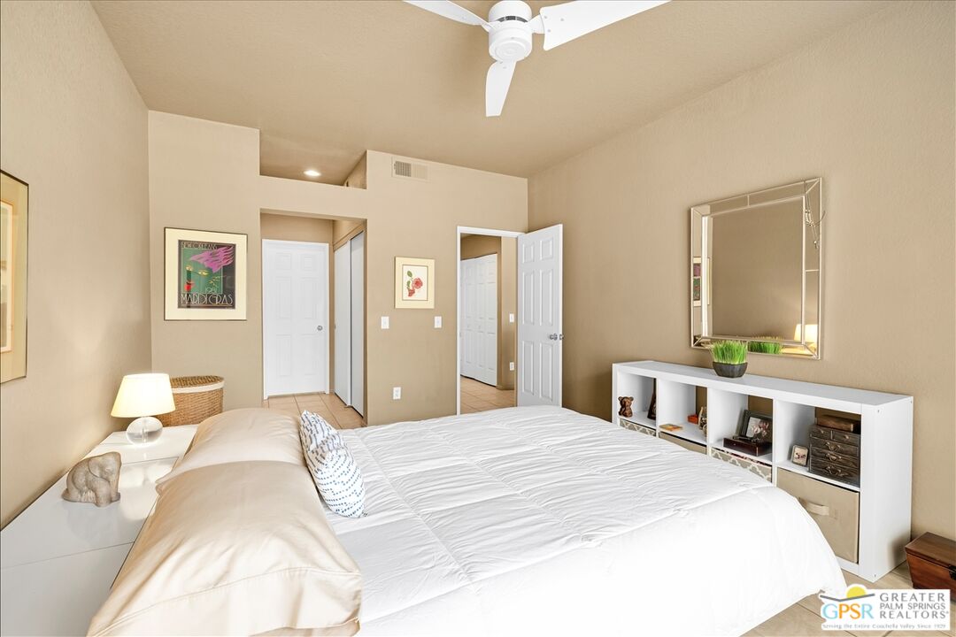 401 El Cielo Road, Unit 227 Palm Springs, CA 92262 - Photo 18 of 43 a bedroom with a bed and a chandelier