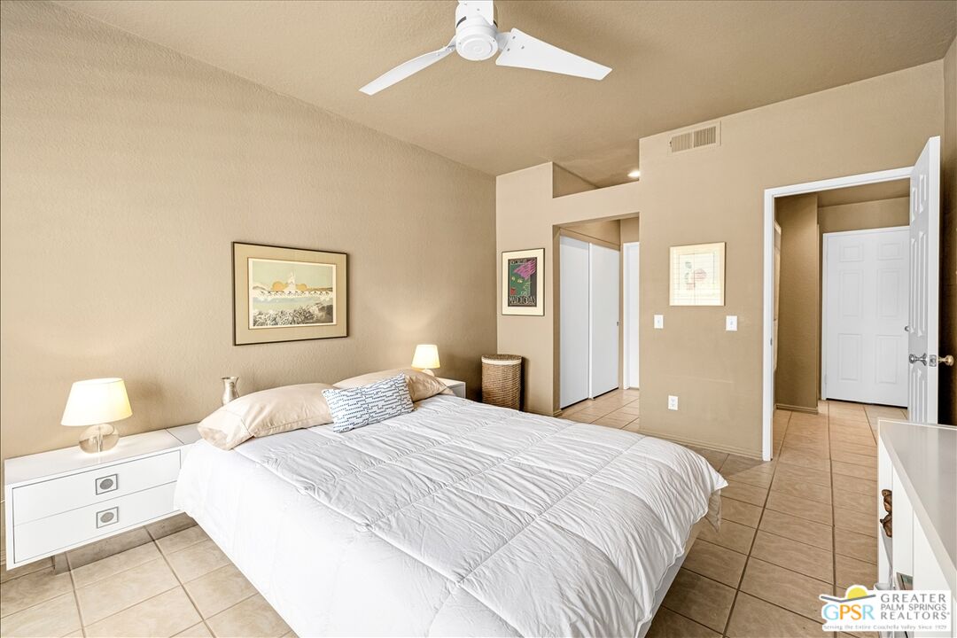 401 El Cielo Road, Unit 227 Palm Springs, CA 92262 - Photo 19 of 43 a bedroom with a bed and a lamp