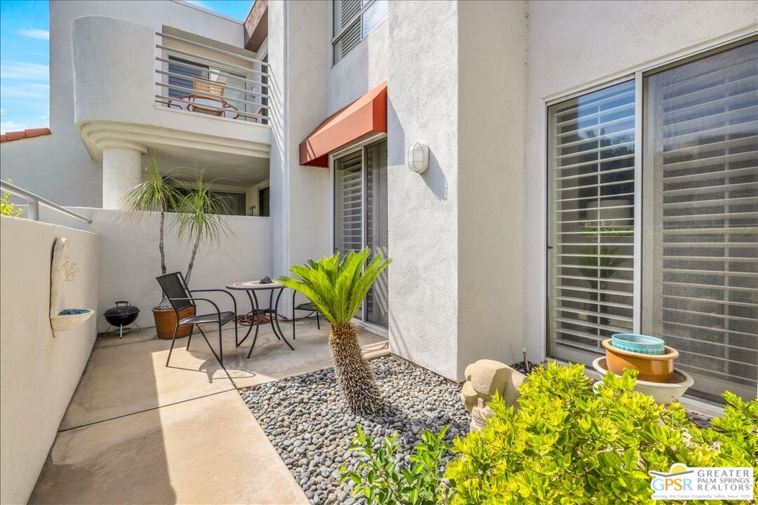 401 El Cielo Road, Unit 227 Palm Springs, CA 92262 - Photo 26 of 43 a view of a patio with table and chairs and potted plants