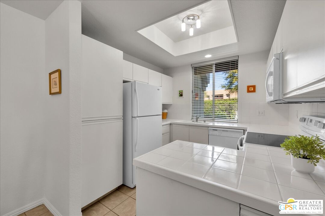 401 El Cielo Road, Unit 227 Palm Springs, CA 92262 - Photo 8 of 43 a kitchen with refrigerator and window