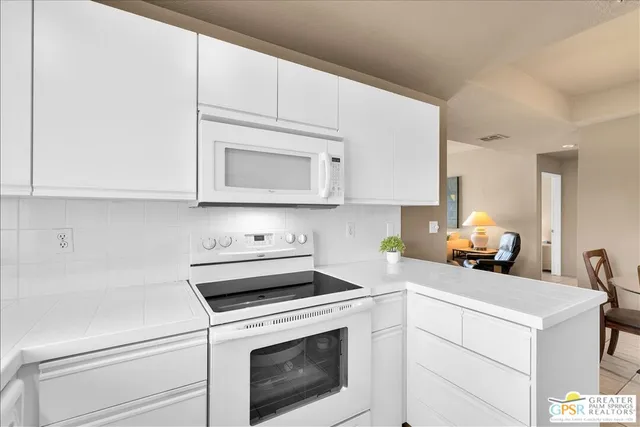 a kitchen with a stove and white cabinets