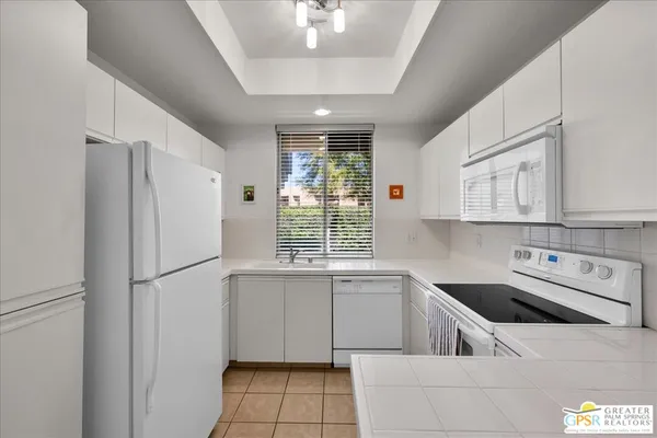 a kitchen with a sink a refrigerator and cabinets