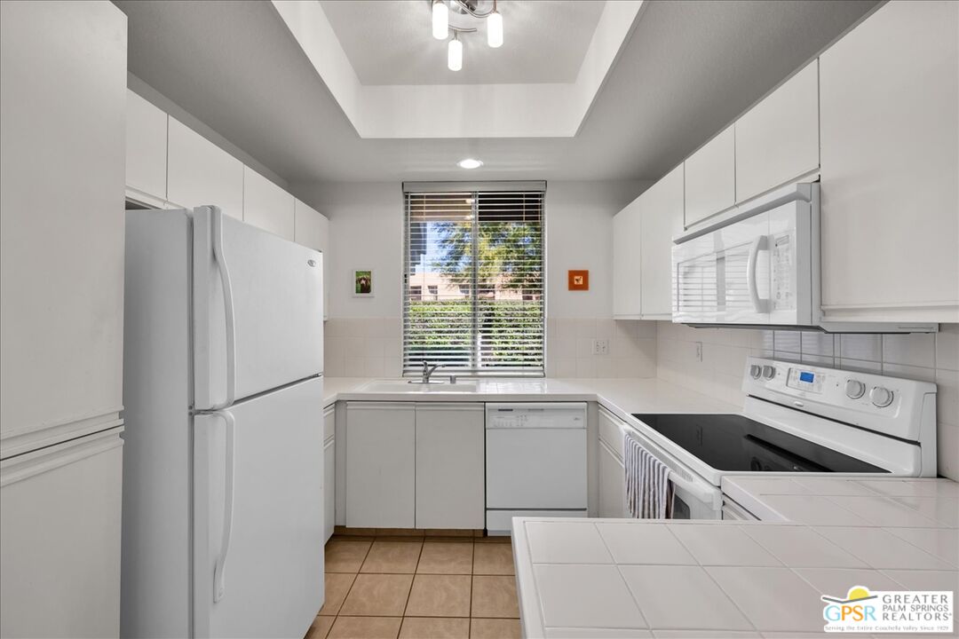 401 El Cielo Road, Unit 227 Palm Springs, CA 92262 - Photo 9 of 43 a kitchen with a sink a refrigerator and cabinets