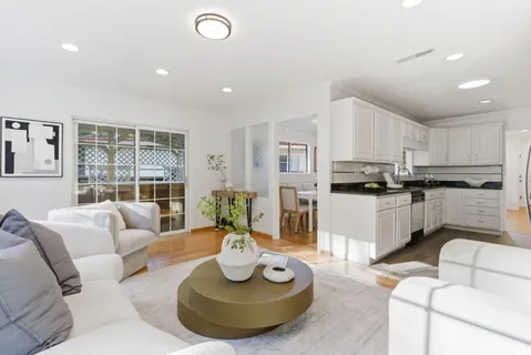 a living room with furniture kitchen and a large window
