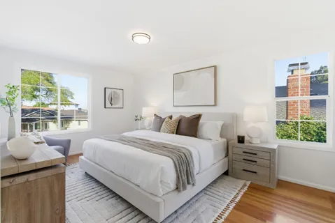 a large bedroom with a bed and wooden floor