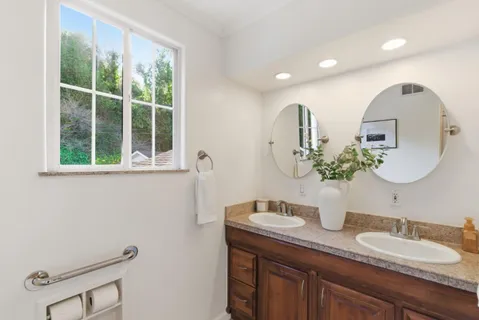 a bathroom with a granite countertop sink and a mirror
