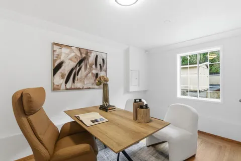 a view of a workspace with furniture and a window