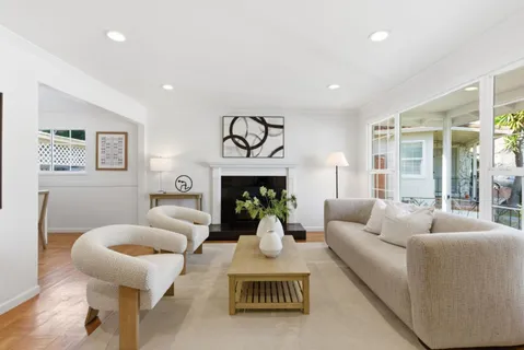 a living room with furniture a fireplace and a chandelier
