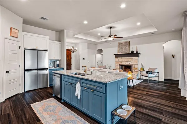 a kitchen with kitchen island a sink stove and refrigerator