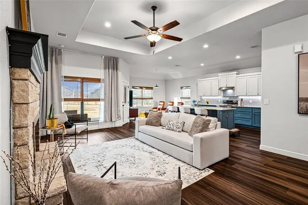 a living room with furniture kitchen view and a large window