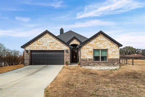 a front view of a house with a yard and garage
