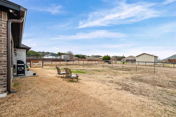 a view of a lake with a yard and a large tree