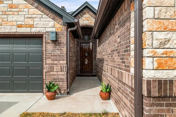 a view of a door of the house with a potted plant