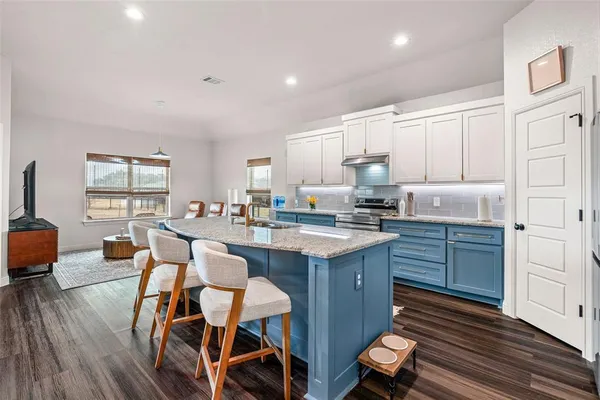 a kitchen with granite countertop white cabinets and stainless steel appliances