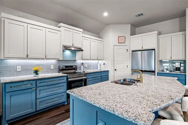 a kitchen with stainless steel appliances granite countertop a stove refrigerator and cabinets