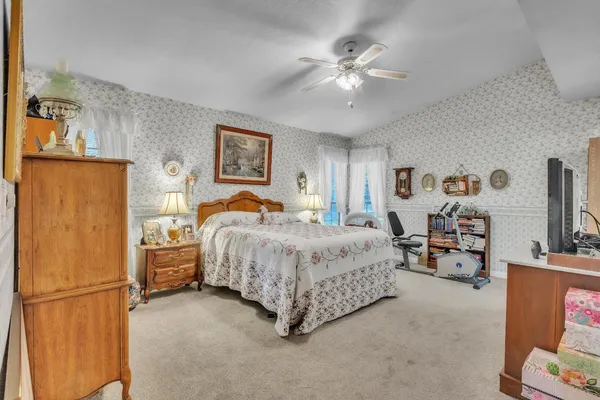 a spacious bedroom with a bed and a chandelier
