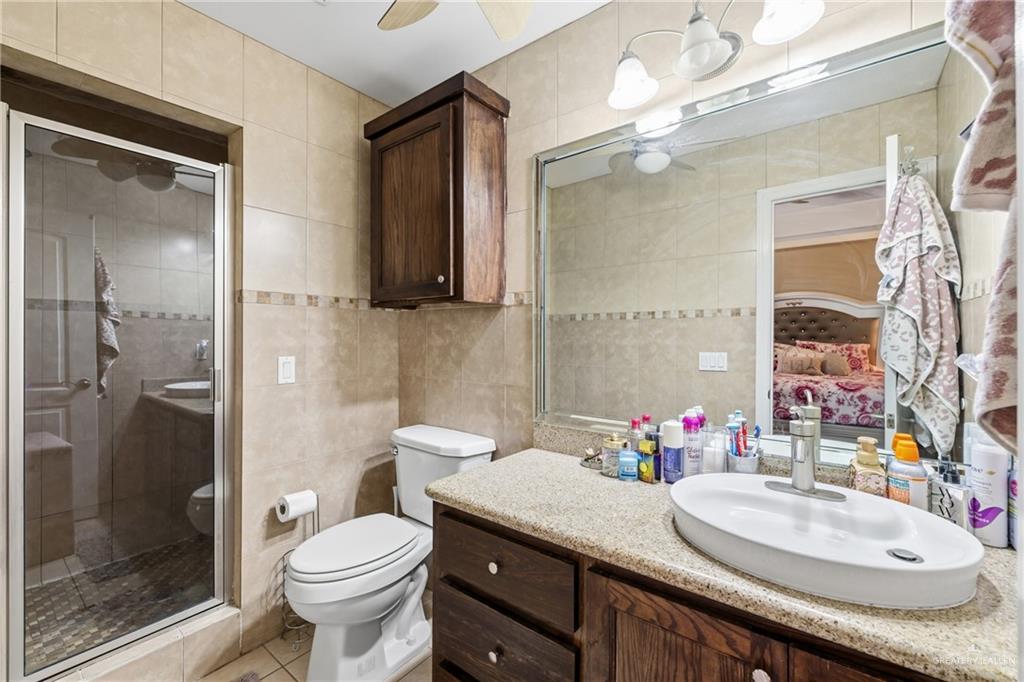 3005 South L Street, Unit 3 McAllen, TX 78503 - Photo 11 of 14 a bathroom with a granite countertop sink mirror and toilet